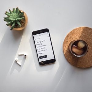 phone on a desk with airpods